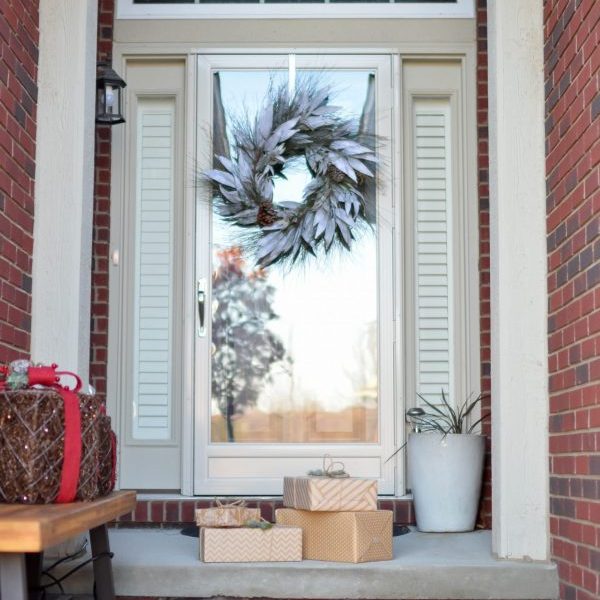 Decorated door with wreath and holiday gifts.